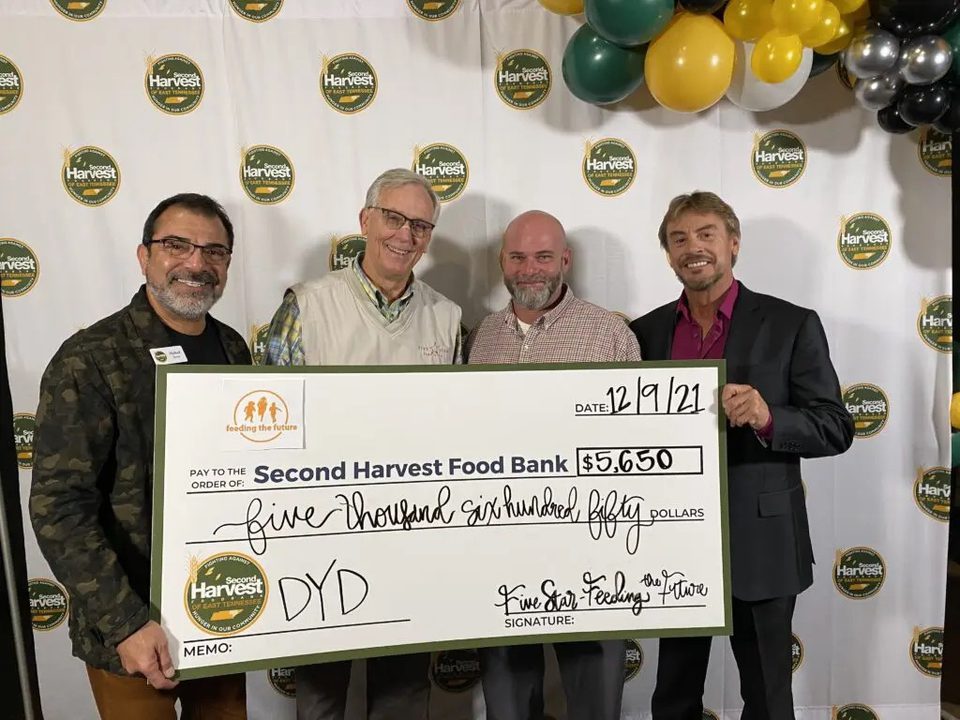 Four men holding big check
