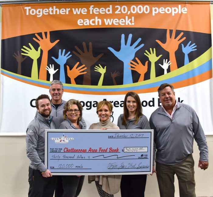 Six employees presenting check