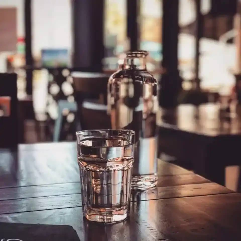 Water in a glass in front of water jug